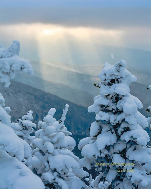 sunbeam over cascade mountain summit in winter